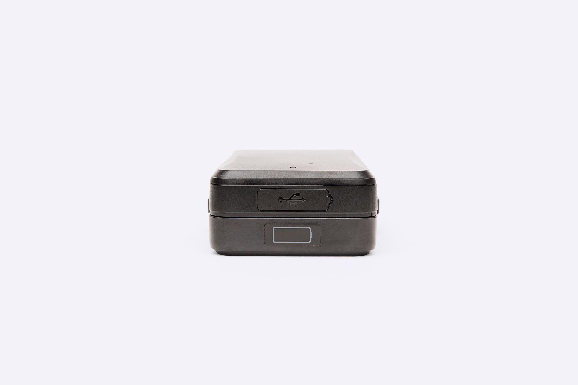 A close-up view of the Protect Plus Strong Magnet GPS Tracker showing its USB charging port, power button, and a visual battery level indicator on a small display.