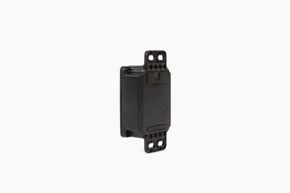 Side view of the black AssetTrack Mini GPS tracker showing its compact design and versatile mounting options, including magnetic and flange attachments. Ideal for securing construction equipment with a long-lasting 5-year battery and global tracking.