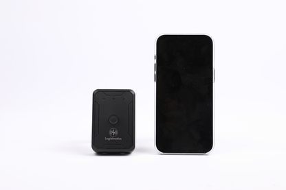 Small black GPS device next to a smartphone on a white background